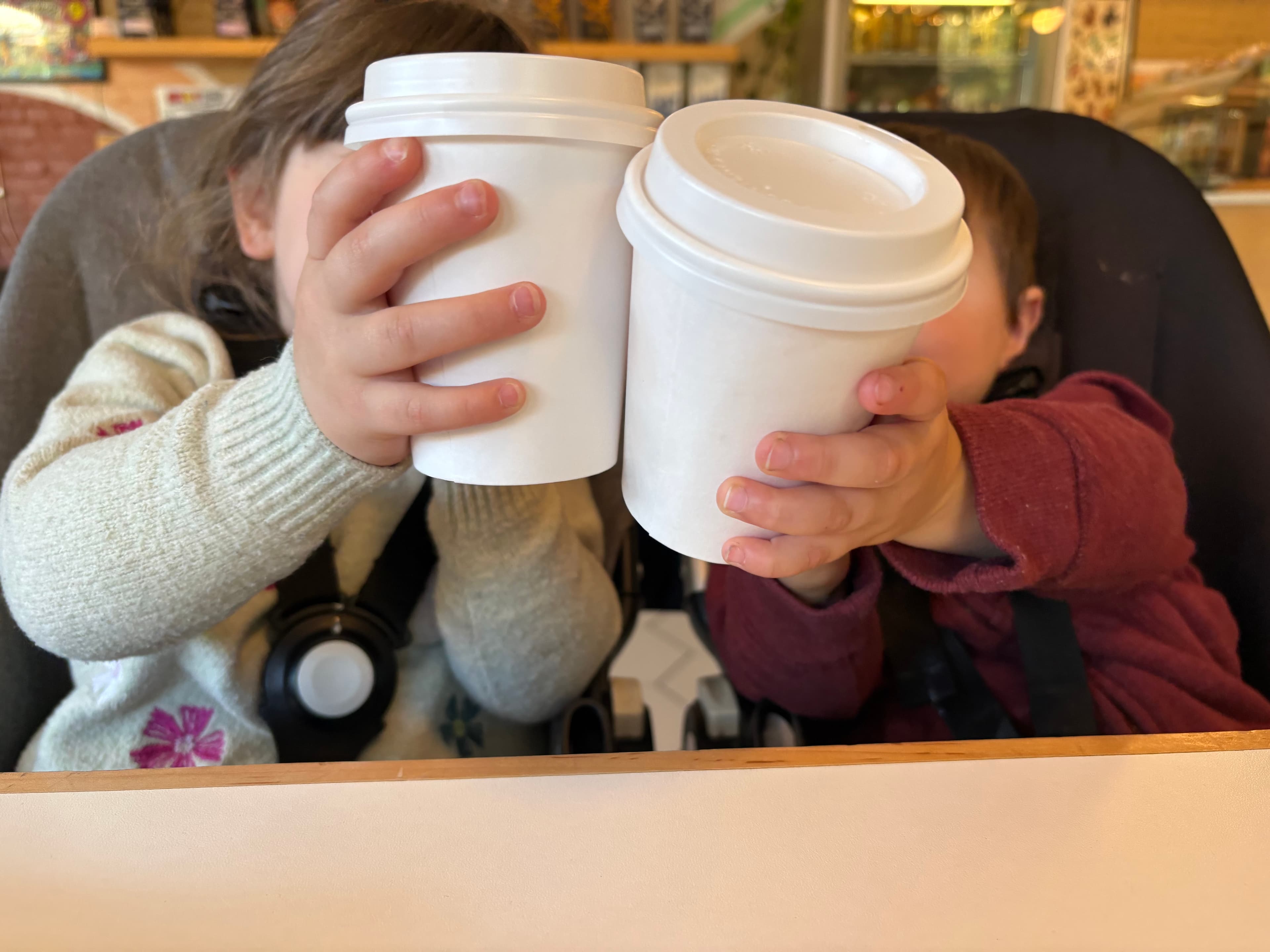 Two children enjoying steamers at a coffee shop